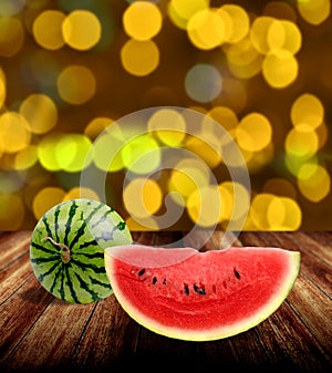 Watermelon on wooden tabel with yellow bokeh light