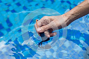 Waterproof audio device submerged in water. Headphones with bone conduction technology. Male hand submerged in water