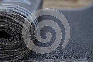 Waterproof bitumen roll covered with insulation materials, abstract background, closeup texture