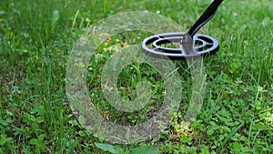 A waterproof black plastic metal detector in action close up