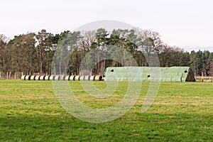 A waterproof covered stack of hay bales standing in a field