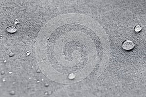 Waterproof droplets on fabric. Grey Canvas Polyester texture synthetical for background. Black polyester textile backdrop for