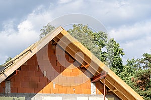 Waterproof layers on gable truss roof brick house in process of construction