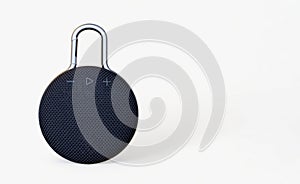 Waterproof round black speaker with carabiner. Digital music and sound concept. Mini, suitable for travel. Modern