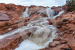 the waters of red rock stream on a rocky mountain side