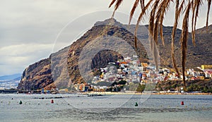 Waterside distant view to Playa de Las Teresitas beach picturesque famous place for tourists, hillside town houses mountainous