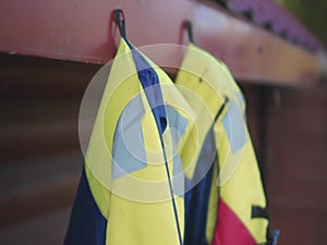 Watersport adventure - colorful life vests hanging on the nail