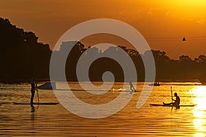 Watersports athlets at sunset wakeboarding and SUP