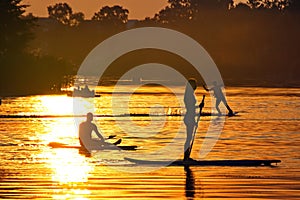 Watersports athlets at sunset wakeboarding and SUP