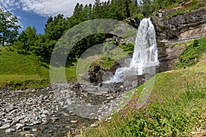 A waterwall on a rocky mountain and a stream formed by the water from waterfall