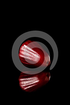 Watery rose apple on a black reflective background