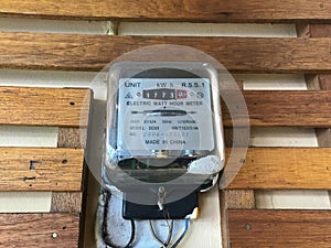 Watt hour electric meter measurement tool on wooden wall