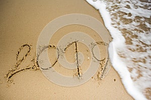 Wave with 2019 texts on the sand.