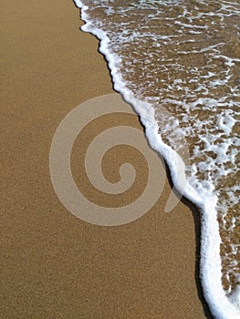 Wave and beach sand closeup