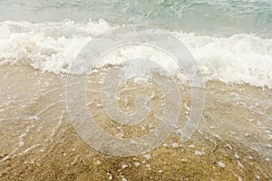 Wave of blue ocean on sandy beach close up Summer Background