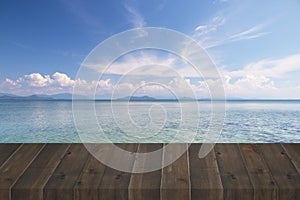 Wave of blue sea on the beach with wooden plank background