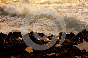 Wave break along rocky shore at Dusk