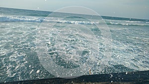 Wave breakes onto the walking Boardwalk in tel aviv