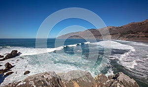 Wave breaking into cove at original Ragged Point peninsula at Big Sur on the Central Coast of California United States