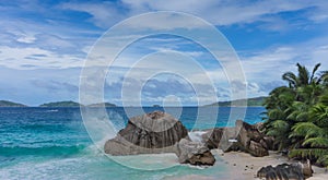 Wave breaking granite rock tropical beach