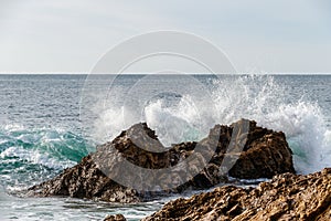 Wave breaking on rocks offshore in Laguna Beach, california.