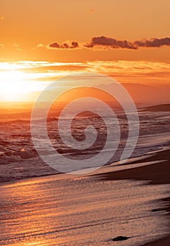 Wave breaking on the beach forming white foam