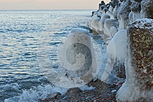 The wave breaks against an icy stone