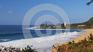 Wave breaks on the beach at Waimea bay in Hawaii