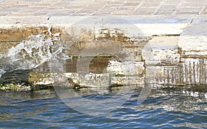 Wave of a canal slamming on stone steps