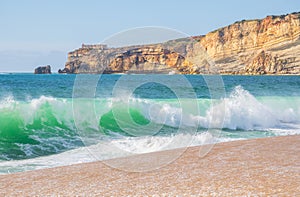 Wave and cliffs in Atlantic Ocean on the beach in NazarÃ©, Portugal photo