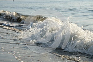 Wave coming onto shore at low tide photo