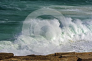 Wave crashing against rocks on the beach