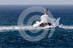 Wave crashing over Longships Lighthouse