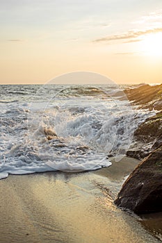 Wave crashing into rock at sunset on the beach in Mazunte Oaxaca Mexico