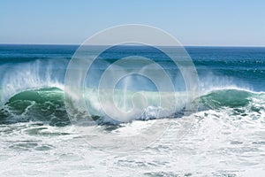 Wave crest breaking along beach