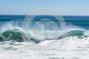 Wave crest breaking along beach photo