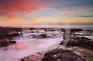 Wave flows over weathered rocks and boulders