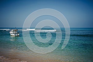 Wave on Hikkaduwa Beach with diving boat photo