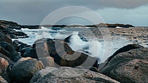 Wave hiting rocks at sunset