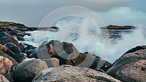 Wave hiting rocks at sunset