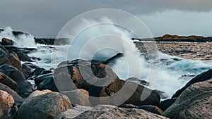 Wave hiting rocks at sunset