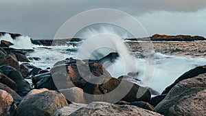 Wave hiting rocks at sunset