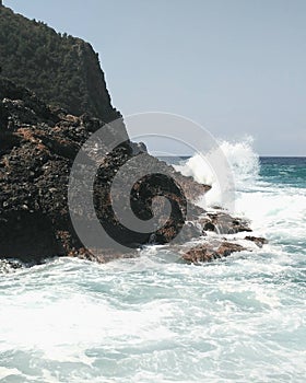 Wave hits the rock. Big waves in the sea. Island without people. Cleopatra beach in Turkey, Alanya