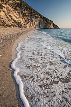 Wave at Milos beach at sunset near the Agios Nikitas village on Lefkada Ionian island, Greece. Evening golden light