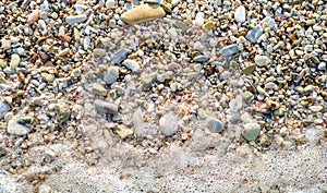 Wave on pebbly beach shore