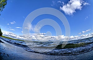 Wave rages and runs to the shore, fish-eye