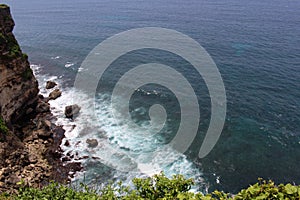 Wave, rocks, and ocean under Uluwatu Pura in Bali. Taken January 2022