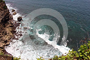 Wave, rocks, and ocean under Uluwatu Pura in Bali. Taken January 2022