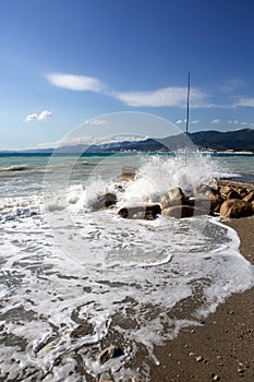 Wave on the rocks. Pebble beach in the resort of Kabardinka, Krasnodar region, Black sea. Waves and surf on a pebble beach..