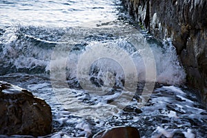 The wave rolls on the rocks. Sea surf. Frozen movement.